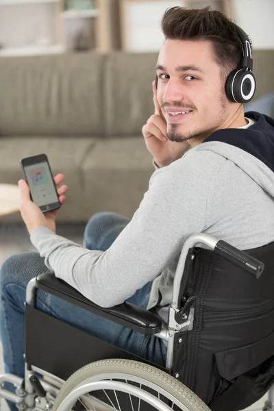 Junger Mann Rollstuhl Telefoniert Vor Farbigem Hintergrund — Stockfoto