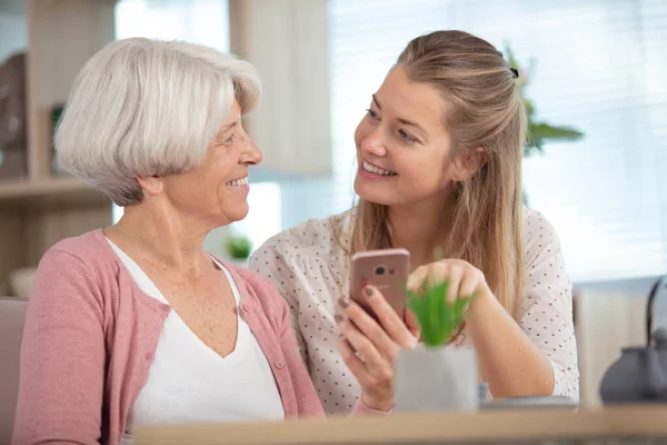 Yetişkin Torunu Olan Yaşlı Bir Kadın Akıllı Telefona Bakıyor — Stok fotoğraf