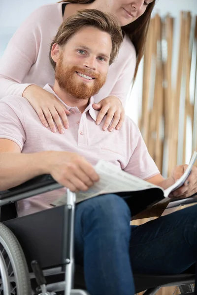 Man Rullstol Med Vacker Kvinna Bakom Sig — Stockfoto
