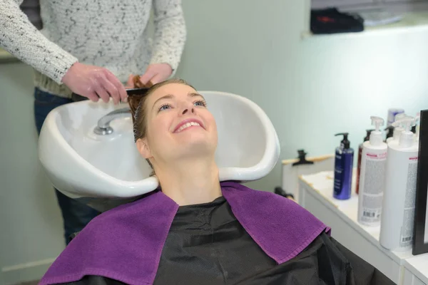 Szczęśliwa Kobieta Dostaje Mycie Włosów Przez Fryzjera — Zdjęcie stockowe