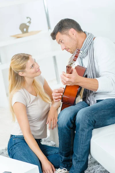 彼の妻のギターを弾く — ストック写真