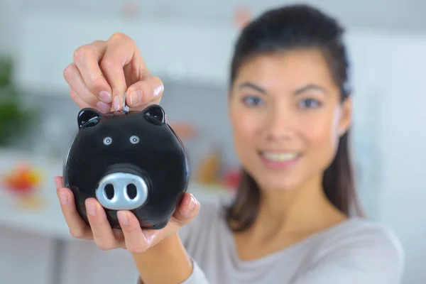Vrouw Geld Steken Piggy Bank Thuis — Stockfoto