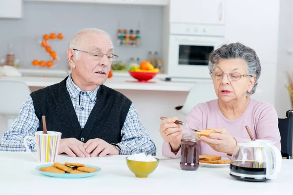 上了年纪的丈夫和妻子一起吃早饭 在餐桌边聊天 — 图库照片