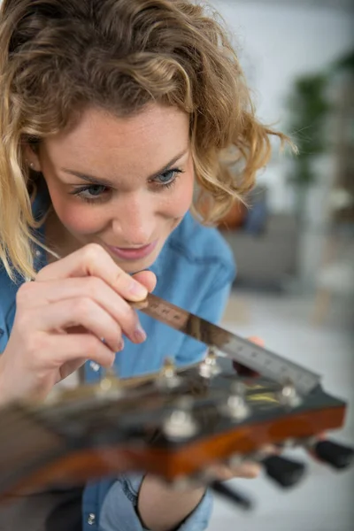 Una Mujer Reparando Una Guitarra —  Fotos de Stock