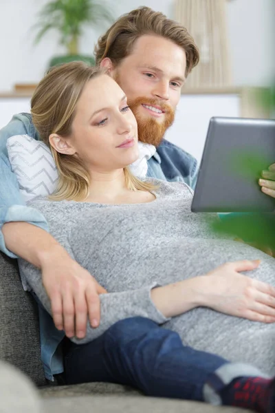Mooi Jong Zwanger Paar Met Tablet Computer Zitten Bank — Stockfoto