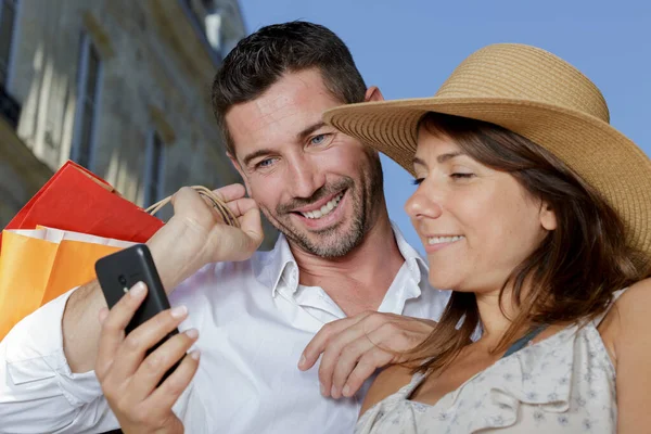 Casal Olhando Para Smartphone Enquanto Fora Compras — Fotografia de Stock
