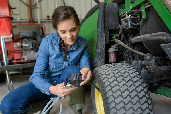 Kvinna Kontrollerar Lufttrycket Ett Traktordäck — Stockfoto