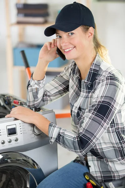 Técnico Feminino Falando Por Telefone Durante Reparação Máquina Lavar Roupa — Fotografia de Stock
