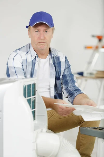 Confused Man Attempting Assemble Air Conditioning Unit — Stock Photo, Image
