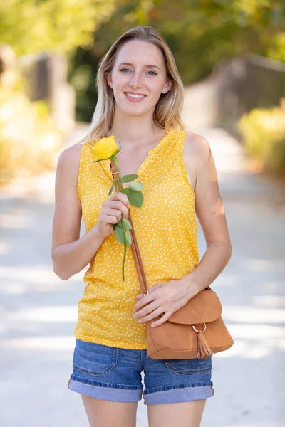 一个拿着黄色玫瑰的年轻漂亮女子的画像 — 图库照片