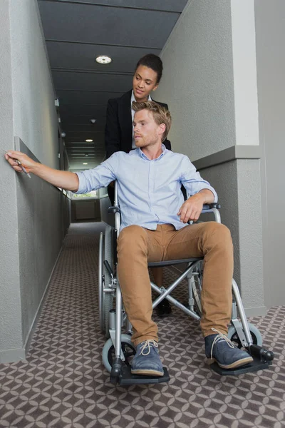 坐在轮椅上的男人被推回房间 — 图库照片
