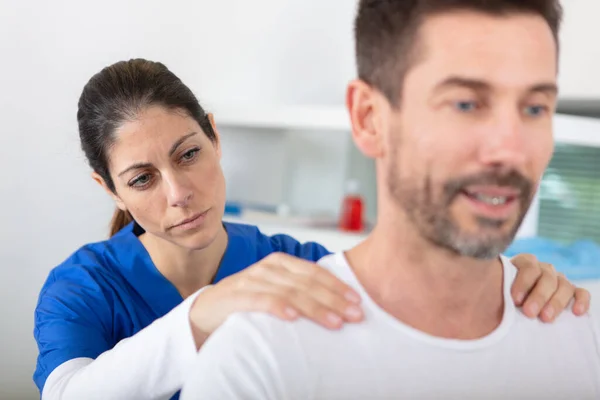 Junge Attraktive Ärztin Macht Nackenmassage Für Männlichen Patienten — Stockfoto