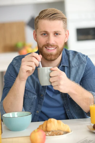 笑容满面的男人 一杯早茶和羊角面包 — 图库照片