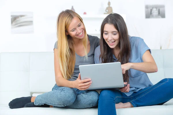 Zwei Lächelnde Freundinnen Sitzen Auf Dem Sofa Und Machen Hausaufgaben — Stockfoto