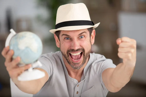 地球儀を持って幸せな男 — ストック写真