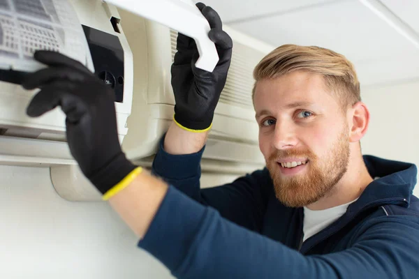 Gelukkig Mannelijk Technicus Repareren Airconditioner Met Schroevendraaier — Stockfoto