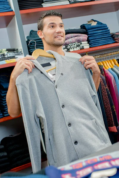 Muž Drží Svetr Proti Sobě Obchodě Oblečením — Stock fotografie