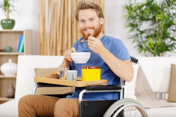 Молодой Взрослый Человек Инвалидной Коляске Наслаждается Миской Хлопьев — стоковое фото