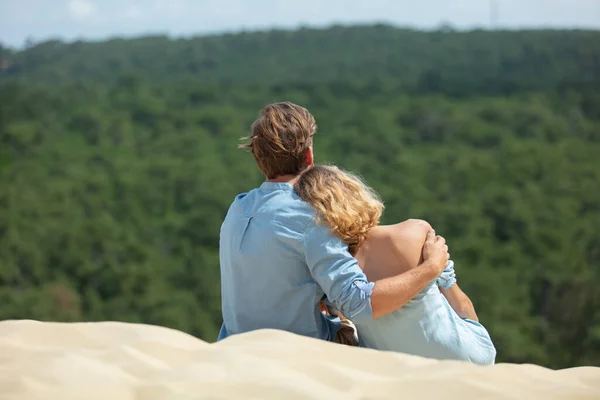 一对浪漫的年轻夫妇一起坐在沙丘上 — 图库照片