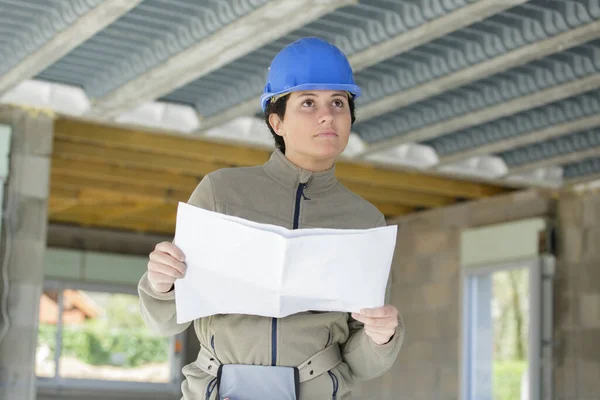 Female Builder Holds Plans Inspects Property — Stock fotografie