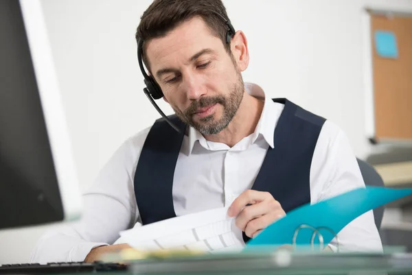 Call Centre Operator Wearing Headset Looking Information — Stock Photo, Image