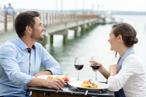 橋の向こうのレストランでデートしてるカップルが — ストック写真