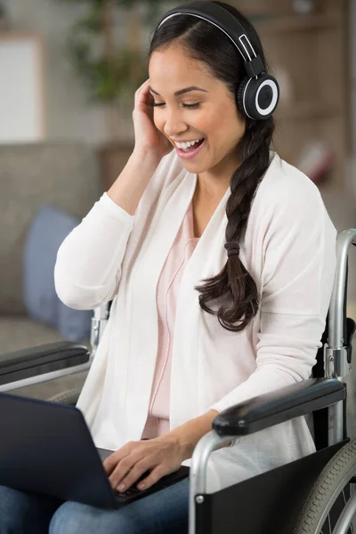 Γυναίκα Αναπηρική Καρέκλα Φορώντας Ακουστικά Και Χρησιμοποιώντας Ένα Φορητό Υπολογιστή — Φωτογραφία Αρχείου