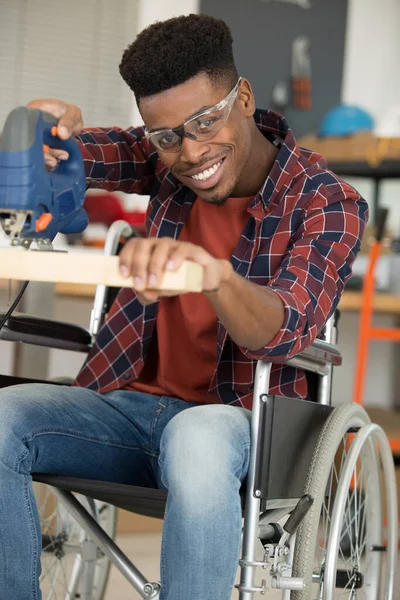 坐轮椅用锯子切割的人 — 图库照片