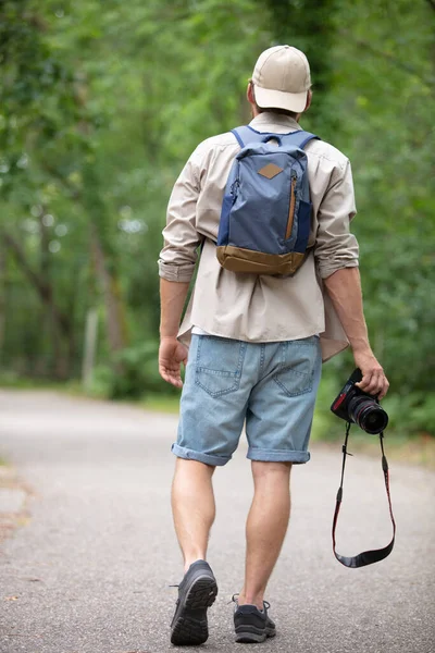 Człowiek Podróżnik Gospodarstwa Aparat Fotograficzny Plecakiem Spacery Lesie — Zdjęcie stockowe