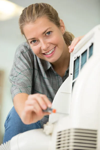 清洁室内空调机的年轻女子 — 图库照片