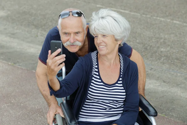 Ηλικιωμένο Ζευγάρι Που Παίρνει Selfie Γυναίκα Αναπηρική Καρέκλα — Φωτογραφία Αρχείου