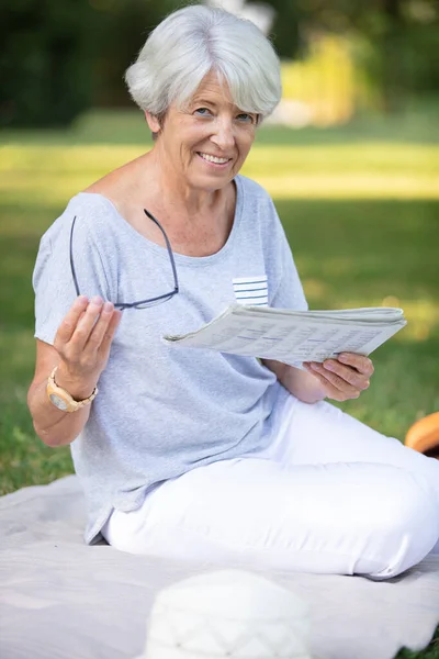 Glückliche Alte Frau Liest Zeitung Auf Dem Gras — Stockfoto
