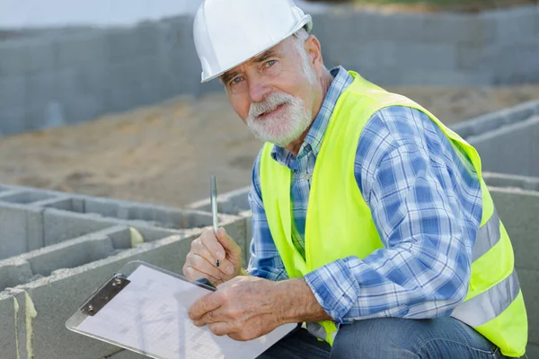Feliz Anciano Constructor Masculino Escribir Notas —  Fotos de Stock