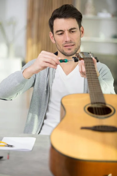 ギターと男を修理する男 — ストック写真