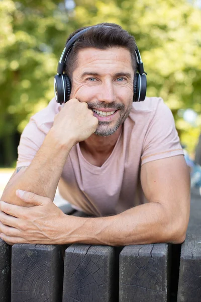 Szczęśliwy Człowiek Słuchający Muzyki Ławce Świeżym Powietrzu — Zdjęcie stockowe