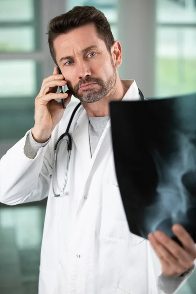 Médico Sério Olhando Para Raio Fazendo Chamada Telefónica — Fotografia de Stock