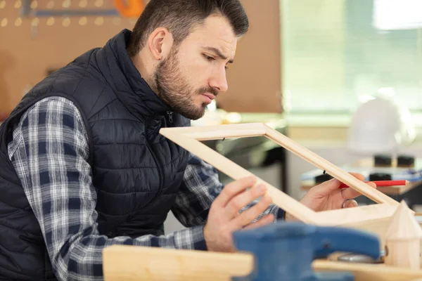 Young Craftsman Measuring Wooden Frame — Stock Photo, Image