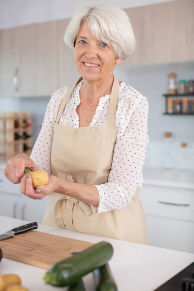 Aktivní Fena Senior Peeling Brambor Kuchyni — Stock fotografie