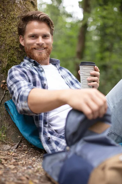Muž Odpočívající Dřevěné Klády Lese Pití Teplého Nápoje — Stock fotografie