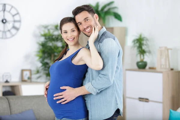快乐的怀孕夫妇在家里拥抱 — 图库照片