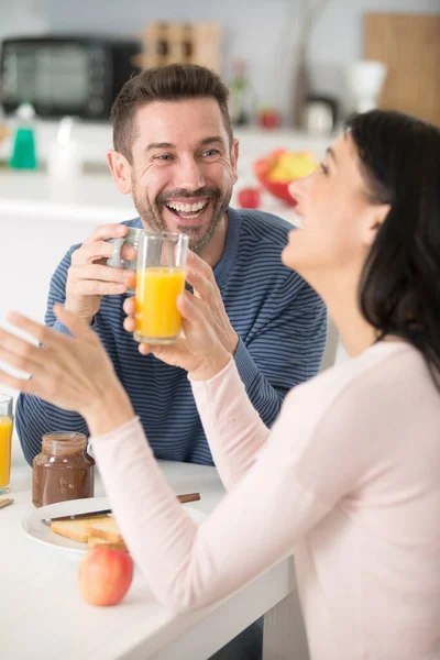 快乐的男人和女人在厨房吃早餐 — 图库照片