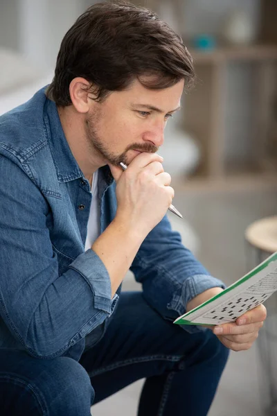 Young Man Sitting Sofa Doing Crossword Puzzle — Stock Photo, Image