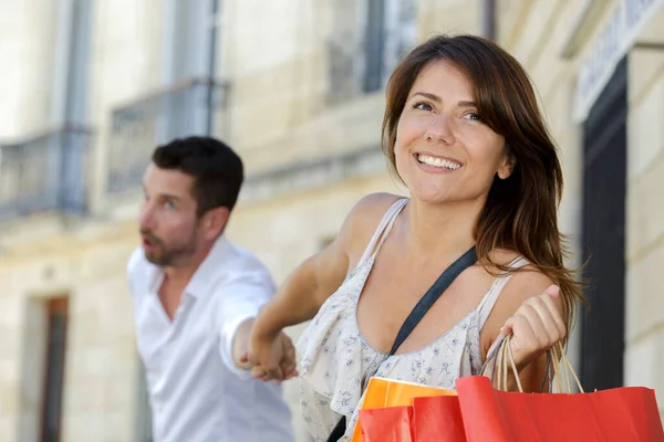 Woman Pulling Boyfriend Store — Stock Photo, Image