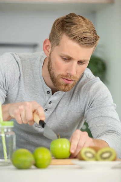Jonge Man Snijden Fruit Keuken — Stockfoto