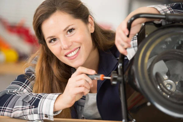 Young Woman Concentrating Repairing Washing Machine — Stock Photo, Image