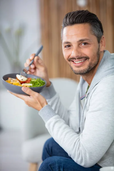 家でサラダを食べてる男 — ストック写真
