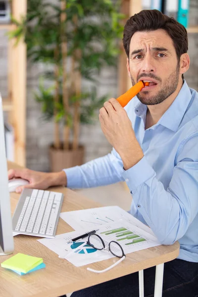 Δεν Εντυπωσιάστηκε Άνθρωπος Τρώει Καρότο Στο Γραφείο Γραφείο Δεν Εντυπωσιάστηκε — Φωτογραφία Αρχείου