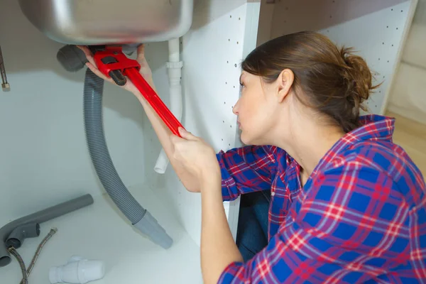 Young Woman Fixing Sink Pipe Kitchen — ストック写真