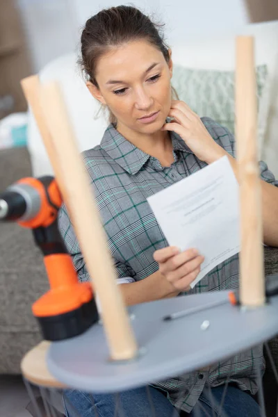 woman reading instructions for assembling furniture