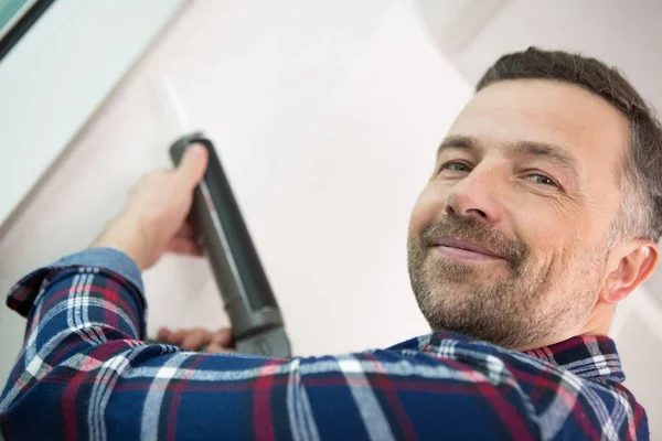 Glad Man Använder Silikon Pistol För Att Reparera Ett Fönster — Stockfoto